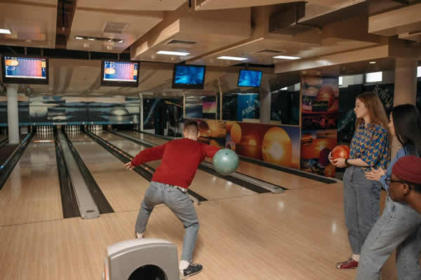 un grupo de adolescentes jugando al bowling