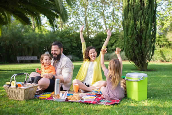 una familia disfrutando un picnic en espacio verde