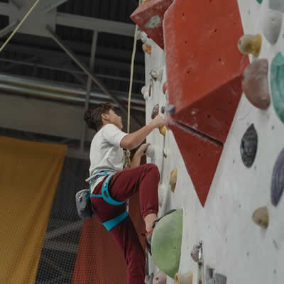 Niño mayor practicando escalada boulder